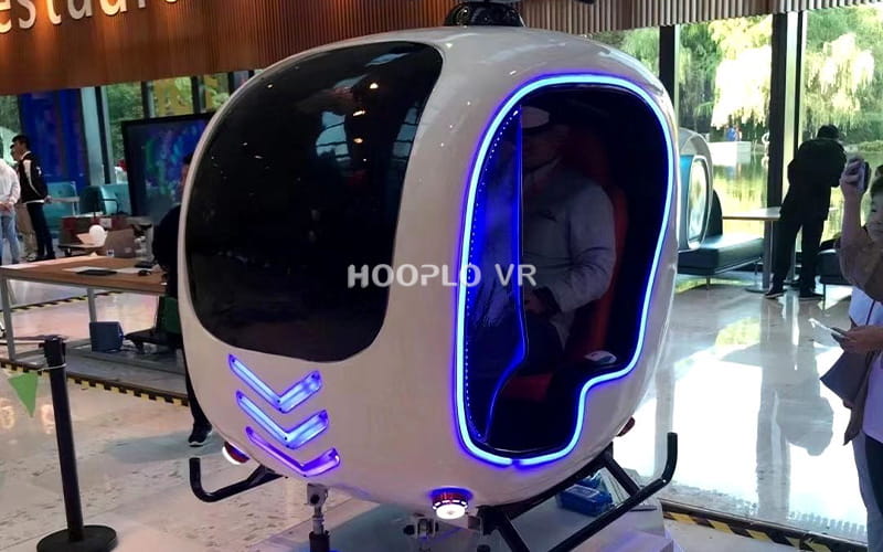 VR Helicopter Simulator installed in an amusement park leisure area with a player experiencing the ride.