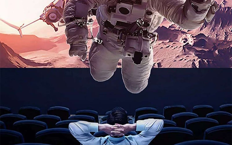 Audience wearing 3D glasses inside a 3D cinema theater demonstrating how stereoscopic depth is created in movies.